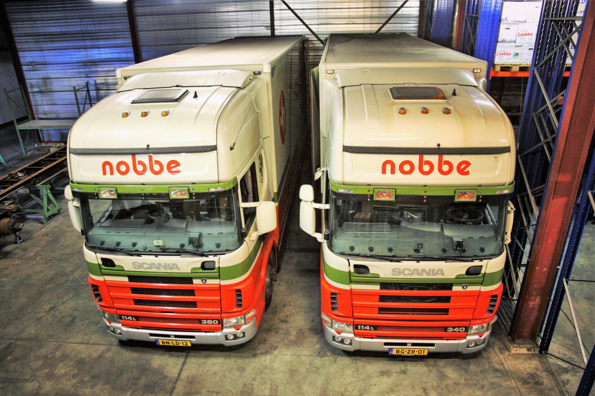 Het wagenpark van Verhuisbedrijf Nobbe (4) Twee verhuiswagen van Verhuisbedrijf Nobbe, gezamenlijk in de verhuisloods.