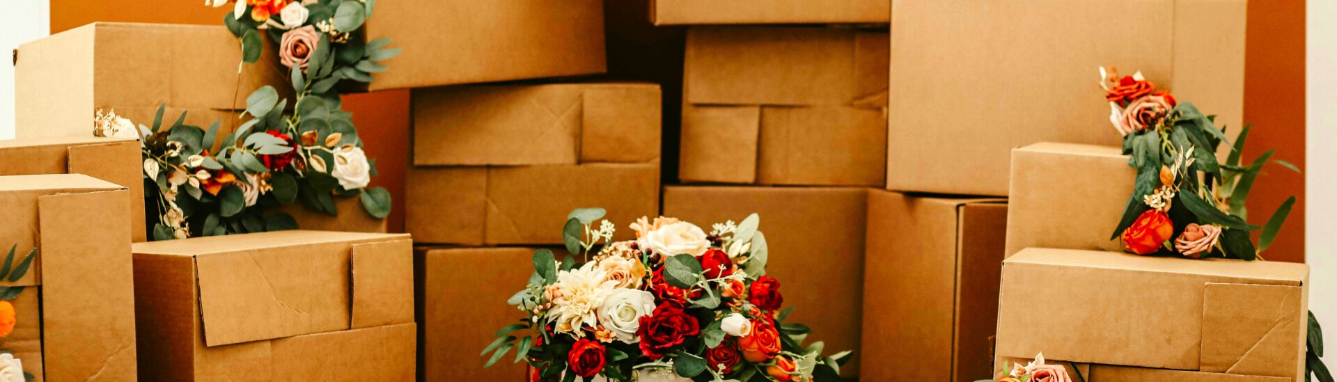 Gestapelde verhuisdozen versierd met bloemen, als symbolische en stijlvolle weergave van een zorgvuldig voorbereide verhuizing.